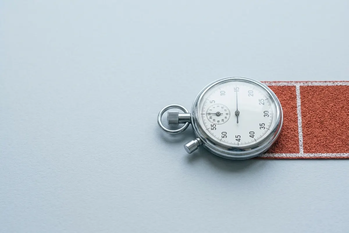 A chrome stopwatch resting on a strip of running track