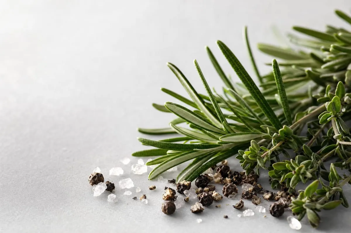 Rosemary and thyme sprigs with cracked peppercorns and coarse salt
