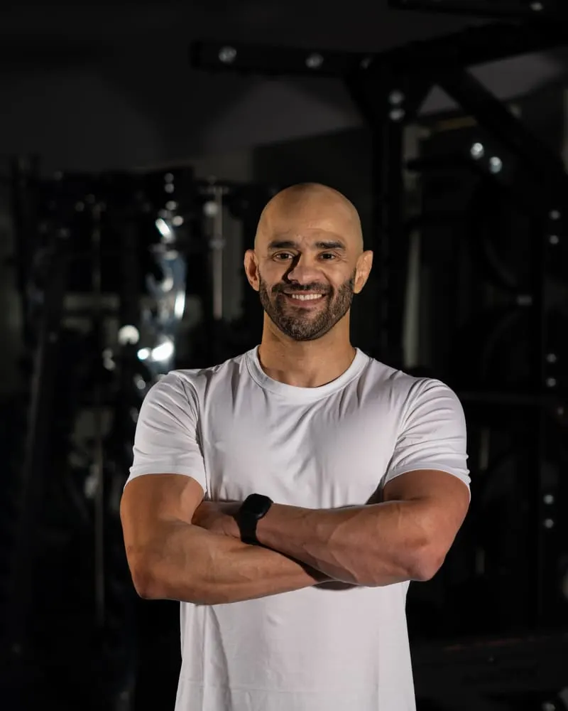 JD Botezelli PhD no estúdio de treino, de braços cruzados