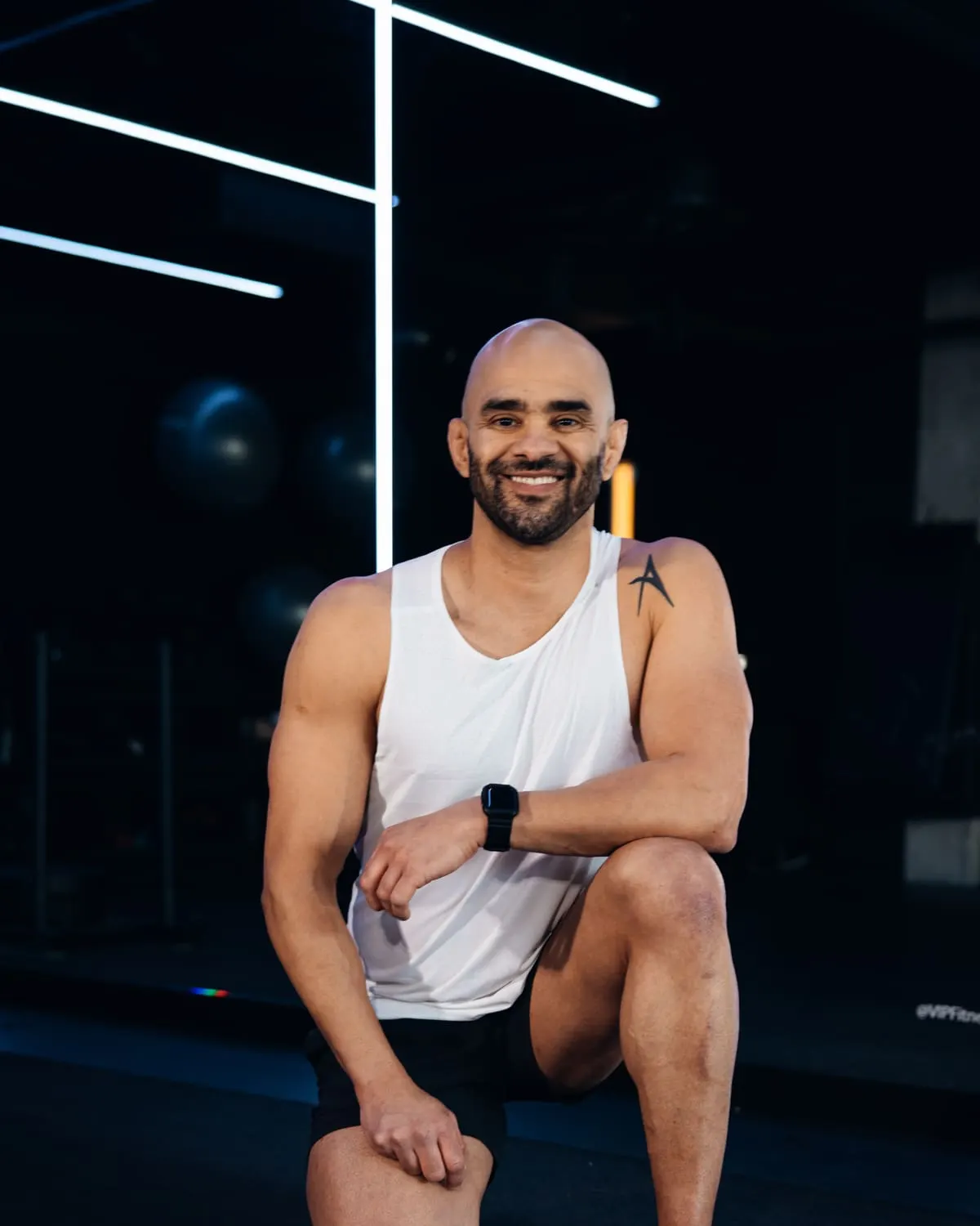 JD Botezelli PhD kneeling on the gym floor