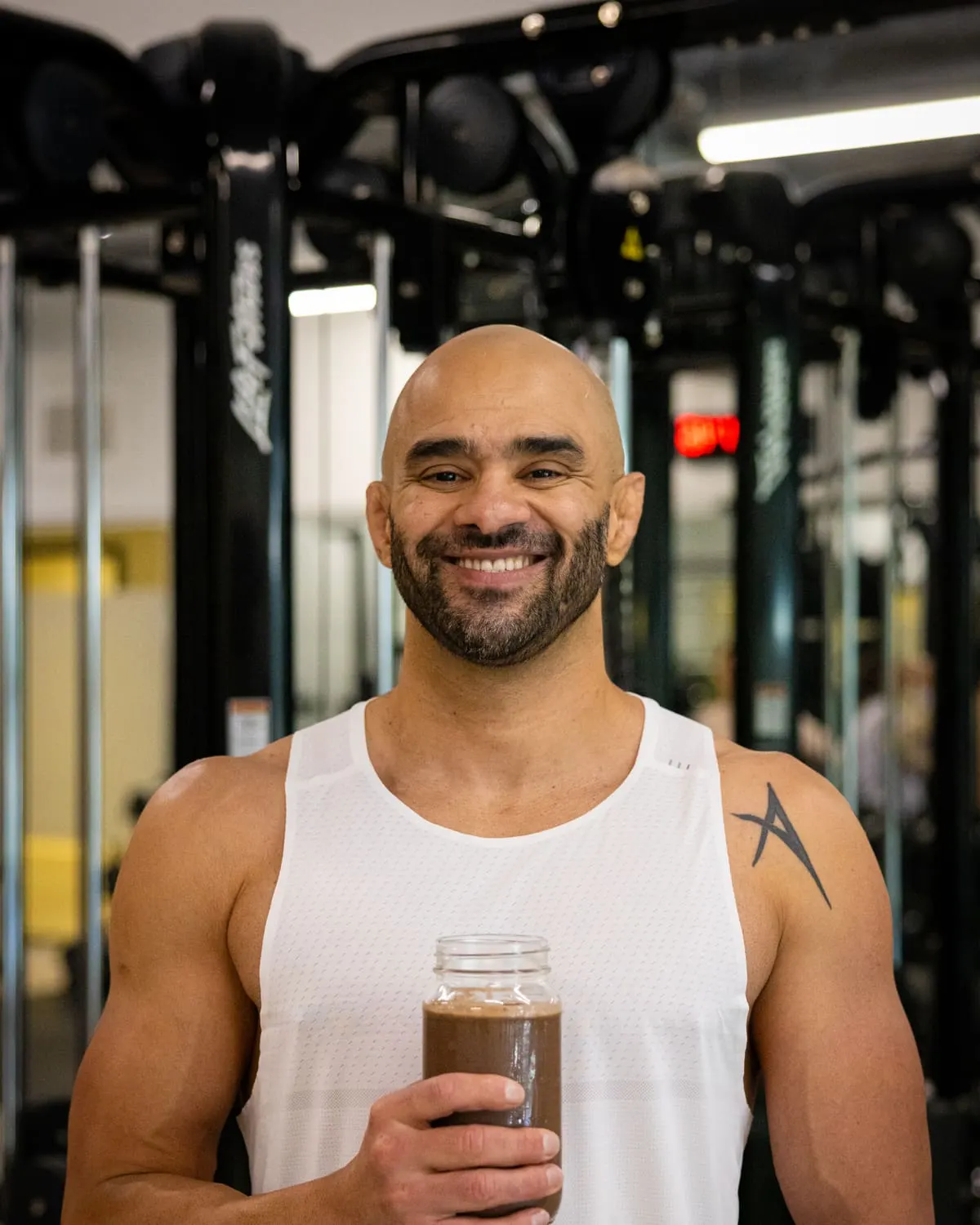 JD Botezelli PhD holding a protein shake in the gym