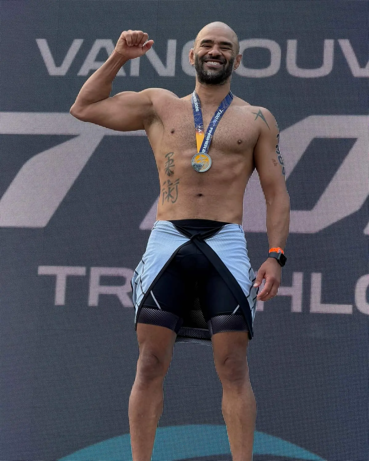 JD Botezelli PhD at the finish line of the Vancouver triathlon, medal on